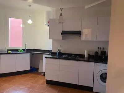 a kitchen with white cabinets and a washing machine at 4-person apartment Guéliz Blida in Marrakech