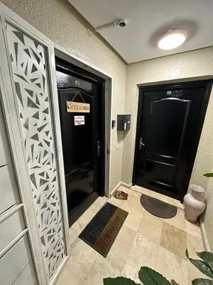 a hallway with two black doors with a sign on it at le CHARM J40 en face CTM Hivernage a 15mn de l'aéroport in Marrakech