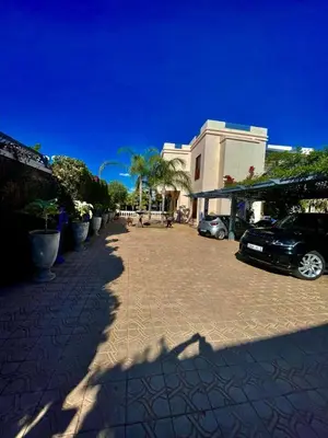 a parking lot with cars parked in front of a building at Villa Souzana in Marrakech