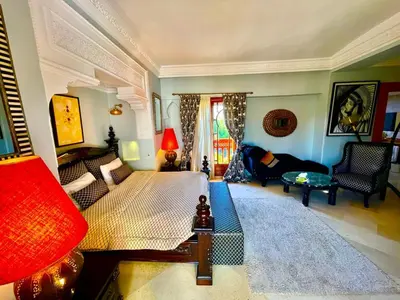 a bedroom with a bed and a couch and a table at Villa Souzana in Marrakech