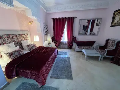 a bedroom with a large bed and red curtains at Villa Souzana in Marrakech