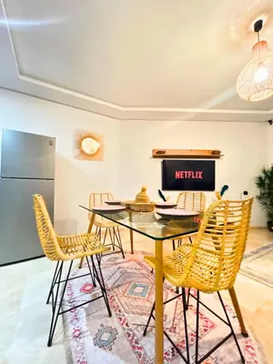 a dining room with a glass table and chairs at Le Cosy de Gueliz avec Piscine et Belle Vue in Marrakech
