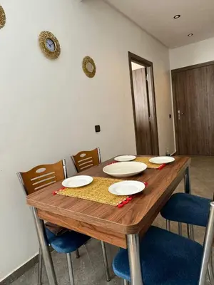 a wooden table with chairs and plates on it at Marrakech Center Getaway Apartment in Marrakech