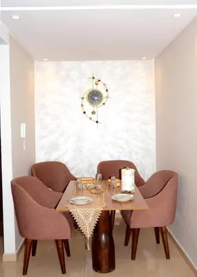 a dining room table with chairs and a clock on the wall at Burj malak in Marrakech