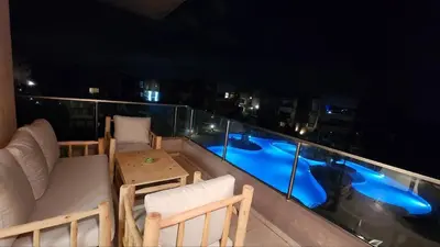 a balcony with chairs and a table and a swimming pool at Prestigia Golf Saphire in Marrakech