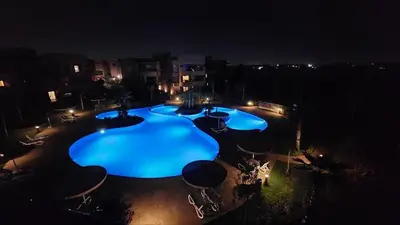 an overhead view of a large swimming pool at night at Prestigia Golf Saphire in Marrakech