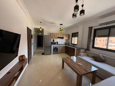 a living room with a couch and a table at charming apartment close to airport Marrakech in Marrakech