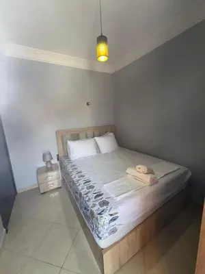 a bedroom with a large bed with white sheets at charming apartment close to airport Marrakech in Marrakech