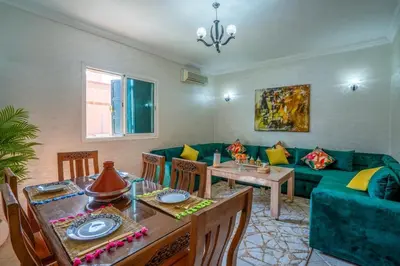 a living room with a green couch and a table at Spacious and Family Apartment in Marrakech
