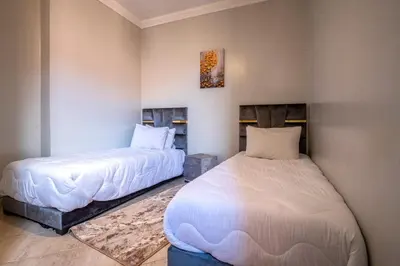 two beds sitting next to each other in a room at Spacious and Family Apartment in Marrakech