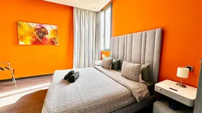 a bedroom with a bed with an orange wall at Cozy appartement Marrakech in Marrakech