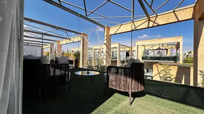 a balcony with chairs and a table on a building at Cozy appartement Marrakech in Marrakech