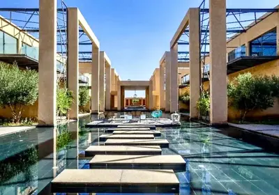a swimming pool in a building with a fountain at Cozy appartement Marrakech in Marrakech