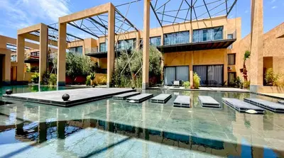 a swimming pool in front of a building at Cozy appartement Marrakech in Marrakech