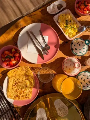 a wooden table with plates of food on it at Riad Doll LallaZwina in Marrakech