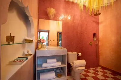 a bathroom with a toilet and a sink and a mirror at Riad Doll LallaZwina in Marrakech