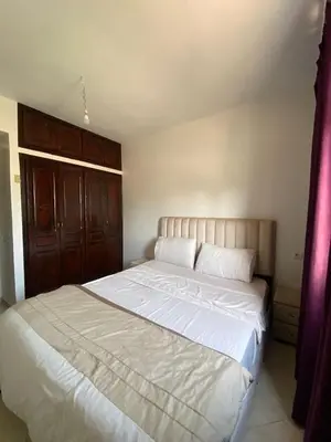a bedroom with a large bed with white sheets at appartement Alaoui in Marrakech