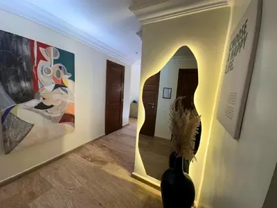 a hallway with paintings on the wall and a vase at Exclusive Luxury Stay with Pool, Jacuzzi and Service in Marrakech