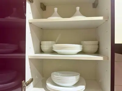 a cabinet filled with white bowls and plates at Exclusive Luxury Stay with Pool, Jacuzzi and Service in Marrakech