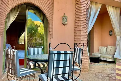 a patio with a table and chairs and a couch at SEJOUR D'EXCEPTION LUXE Et SERENITE MARRAKECH in Marrakech