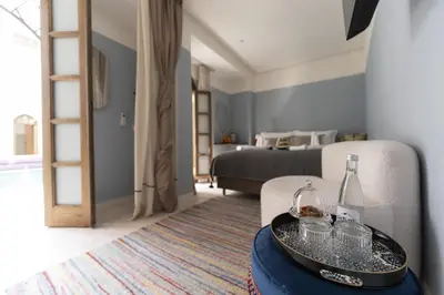a room with a bed and a tray with bottles and glasses at Riad Rumi Marrakech Medina in Marrakech