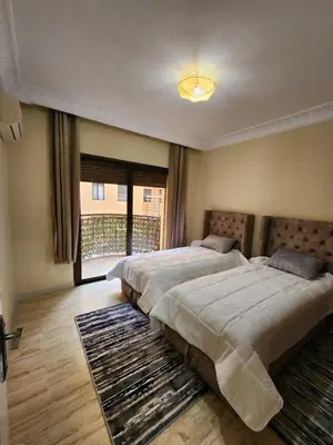 a bedroom with two beds and a large window at Appartement de luxe in Marrakech