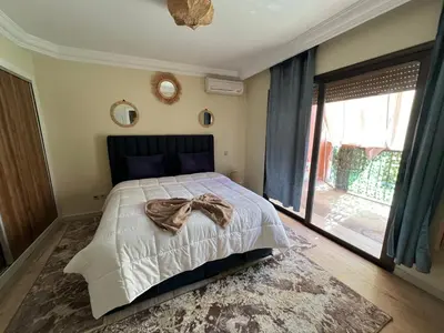 a bedroom with a bed and a large window at Appartement de luxe in Marrakech