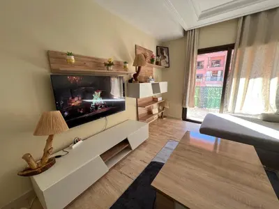 a living room with a flat screen tv on a wall at Appartement de luxe in Marrakech