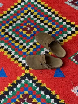 a pair of shoes sitting on a rug at riad medina marrakech in Marrakech