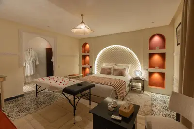 a bedroom with a bed and a table in a room at Riad Dar Lamia Marrakech Médina in Marrakech