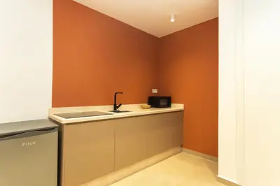 a kitchen with orange walls and a sink and a counter at Suite Soleil Charme, Confort & Emplacement Idéal in Marrakech