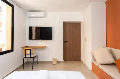 a bedroom with a bed and a television on the wall at Suite Mandarine - Charme et confort chaleureux in Marrakech