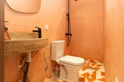 a bathroom with a toilet and a sink at Suite Mandarine - Charme et confort chaleureux in Marrakech