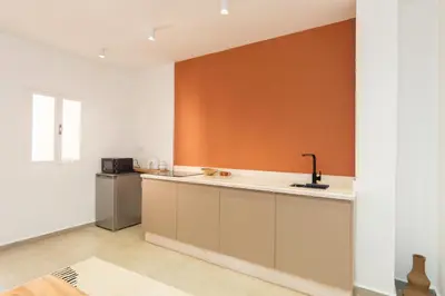 a kitchen with an orange wall and a sink at Suite Mandarine - Charme et confort chaleureux in Marrakech