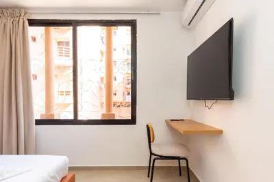 a bedroom with a bed and a desk and a window at Suite Mandarine - Charme et confort chaleureux in Marrakech