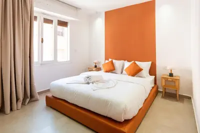 a bedroom with a large white bed with orange walls at Terra Cotta Suite, Luxe & Relaxing Bath in Marrakech