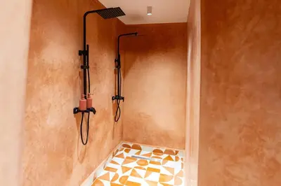 a shower in a bathroom with two shower heads at Cozy suite Comfort et elegance in Marrakech