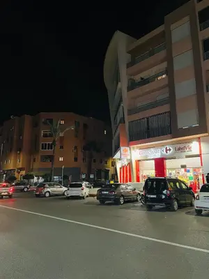 a group of cars parked in a parking lot at night at Appartement charmant à 5 min de Gueliz in Marrakech