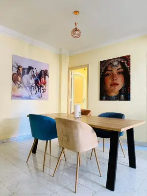 a dining room with a table and two paintings on the wall at Appartement charmant à 5 min de Gueliz in Marrakech
