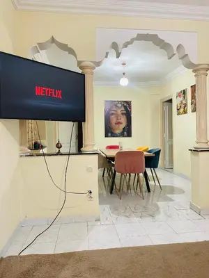 a television in a living room with a table at Appartement charmant à 5 min de Gueliz in Marrakech