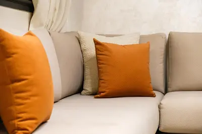 a white couch with orange pillows on it at Modern Appart , Parking , Pool & Fiber wifi , Hivernage City Centre in Marrakech