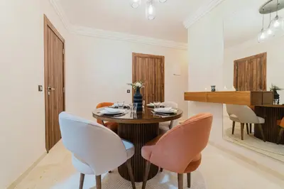 a dining room with a wooden table and chairs at Modern Appart , Parking , Pool & Fiber wifi , Hivernage City Centre in Marrakech