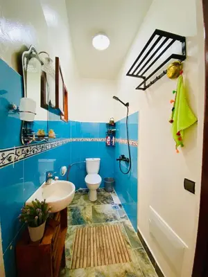 a blue bathroom with a sink and a toilet at Cozy Moroccan-style apartment in Marrakech