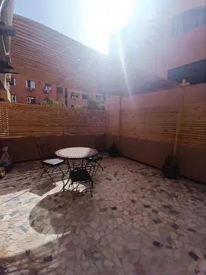 a patio with a table and chairs and the sun at Modern apartment in the Heart of the City in Marrakech