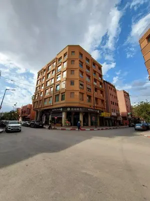 a tall building on a street with cars parked in front at Appartement centre ville marrakech in Marrakech