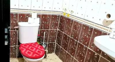a bathroom with a red toilet and a sink at Do7a Marrakech in Marrakech