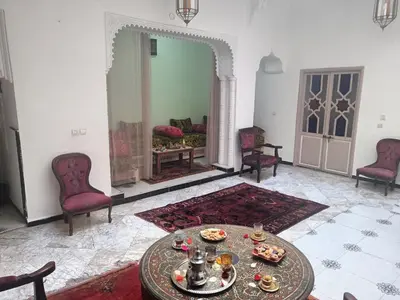 a living room with a table and chairs and a mirror at Dar Le Monde in Marrakech