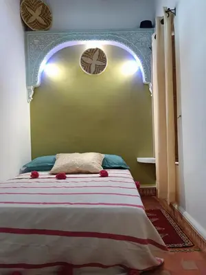 a bedroom with a bed with an arch above it at Dar Le Monde in Marrakech