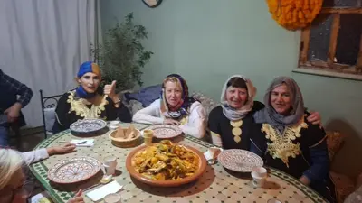 a group of people sitting around a table with food at Dar Le Monde in Marrakech