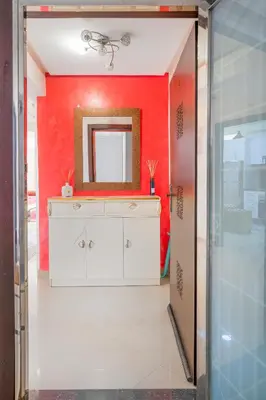 a bathroom with a mirror on a red wall at حي الشرف in Marrakech
